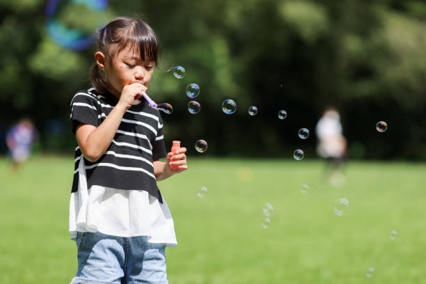 istock Mother and daughter having fun in park with Soap Bubbles 1421196091