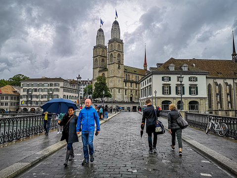 Zurich, Switzerland - September 8, 2019: tourists in front of Grossmunster Cathedral over the bridge of River Limmat in Zurich