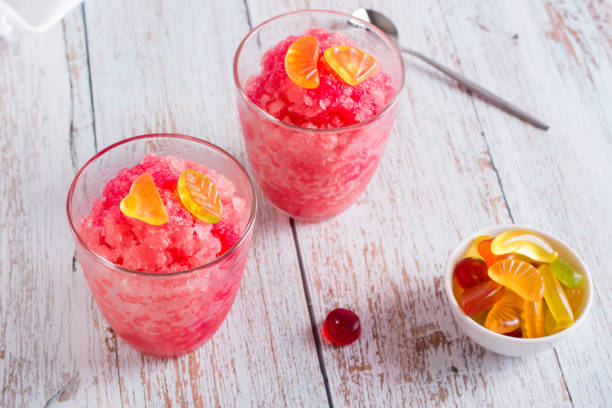 istock Red shaved ice snow cone with syrup and sweets in glasses on the table 1421197862