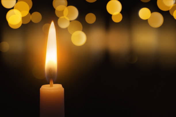 istock Wax candle burning in darkness, bokeh effect. Christmas Eve 1421198160