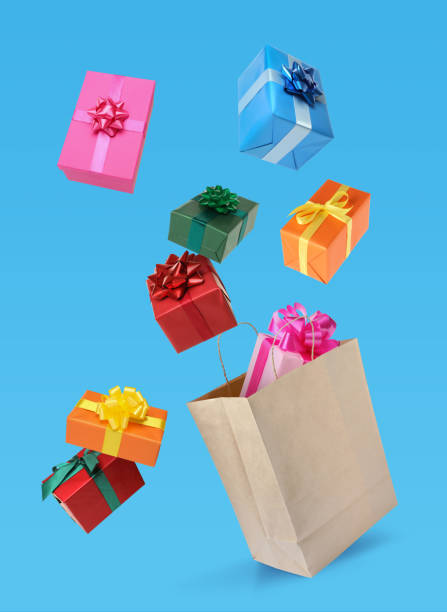 istock Many different gift boxes falling into paper shopping bag on light blue background 1421198284