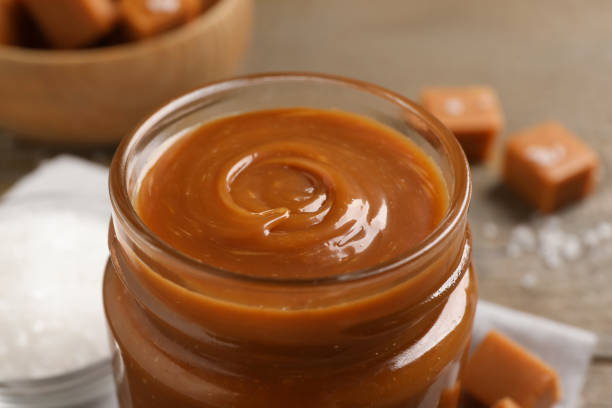 istock Yummy salted caramel in glass jar on table, closeup 1421199003