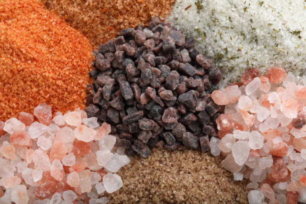 istock Different kinds of salt as background, top view 1421201318