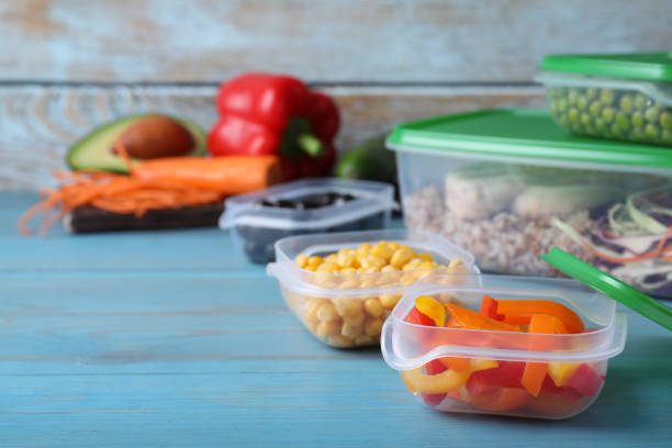 istock Set of plastic containers with fresh food on light blue wooden table, space for text 1421202072