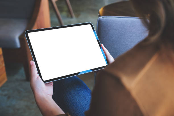 istock Mockup image of a woman holding digital tablet with blank white desktop screen 1421203891