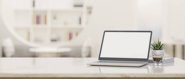 istock Laptop mockup and copy space on modern white workspace tabletop over blurred library 1421205304