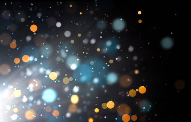 istock yellow and blue defocused lights on a black background in the rays of light. 1421208967