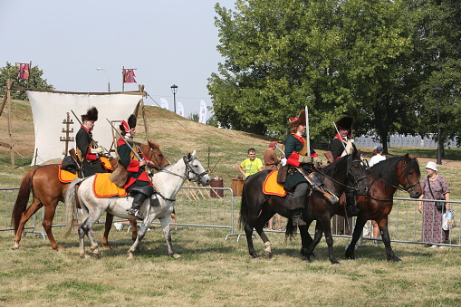 Abbotsford, British Columbia, Canada - August 12, 2005: The Royal Canadian Mounted Police of Canada performing a formal event by thirty-two cavalry, called a Musical Ride, showcasing their equestrian skills, riding in formation while holding their red and white pennons (flags).  They are entering the ring at the beginning of the performance.