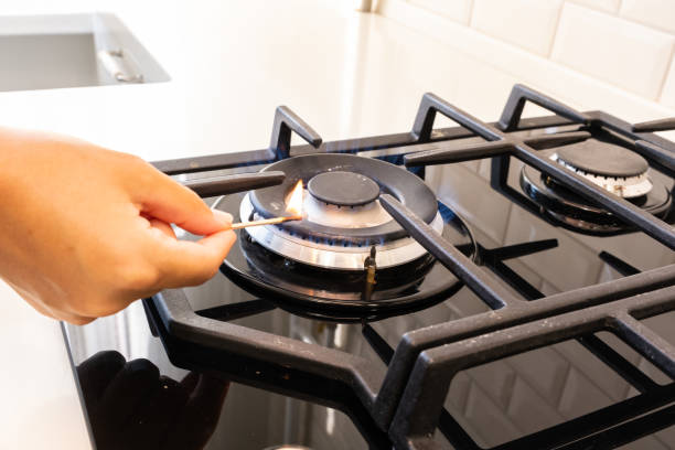 istock Hand with a match ignites a gas burner 1421210325