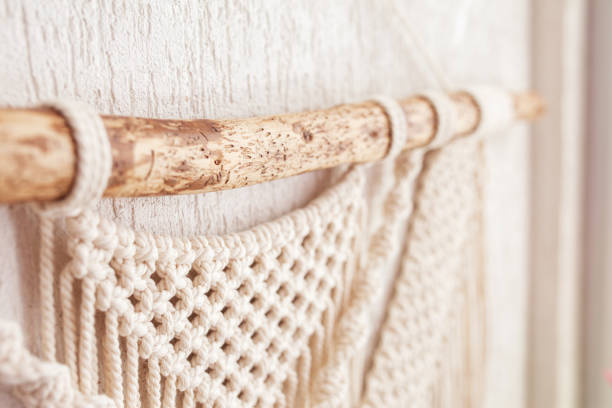 istock Handmade macrame wallhanging. Wooden stick with100% cotton wall decoration.  Macrame braiding and cotton threads. Female hobby.  ECO friendly modern concept in the interior 1421210687