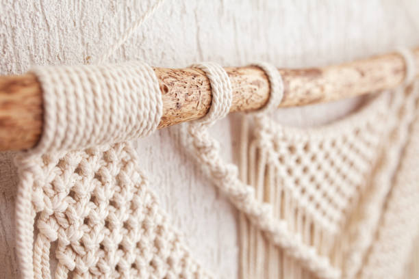 istock Handmade macrame wallhanging. Wooden stick with100% cotton wall decoration.  Macrame braiding and cotton threads. Female hobby.  ECO friendly modern concept in the interior 1421210697