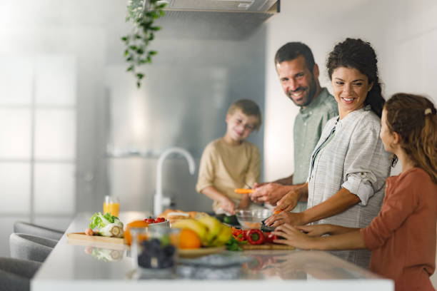 istock Happy family talking while preparing a meal in the kitchen. 1421211641