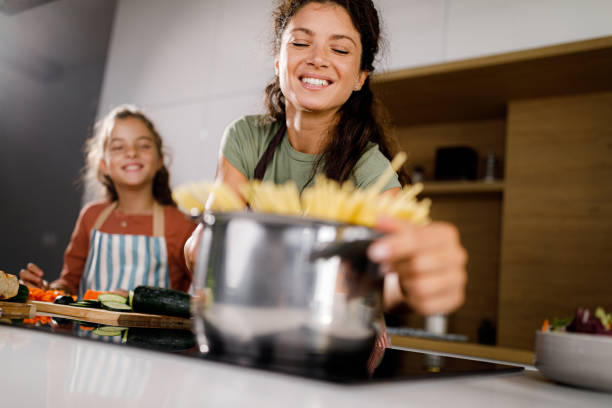 istock Happy mother and her daughter making spaghetti in the kitchen. 1421211809