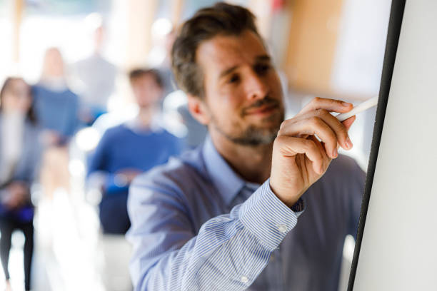 istock Close up of a presenter writing plans during presentation in the office. 1421213568