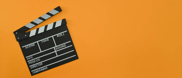 istock A clapper board on orange background with copy space. Cinema minimal concept. 1421214862
