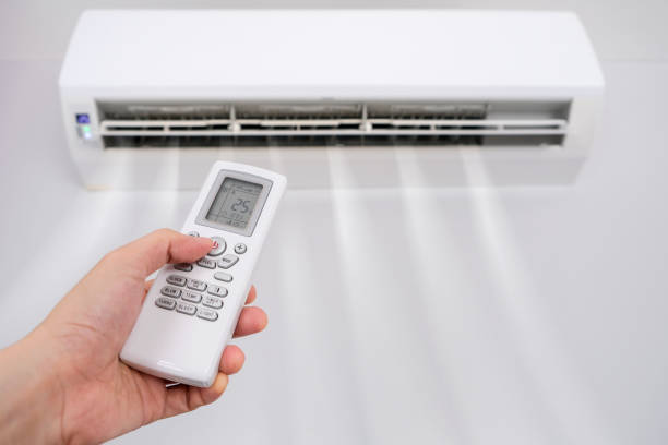 istock Man's hand using remote control open The air conditioner is cooled to 25 degrees Celsius in his bedroom. Health concepts and energy savings 1421215089