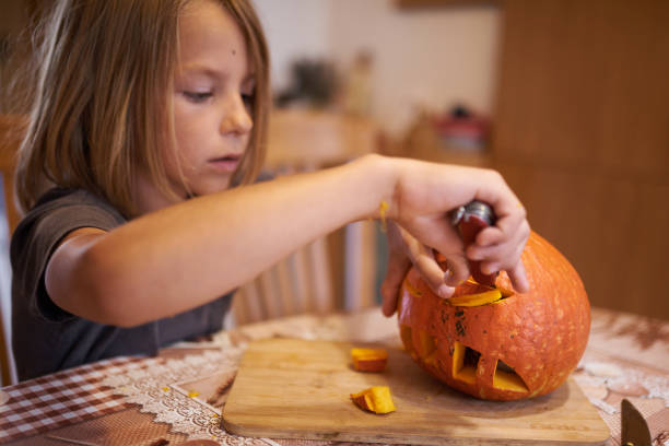 istock 8 year old boy carving Halloween pumpkin 1421216584