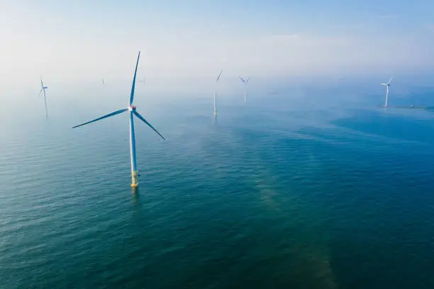 Photo of Wind turbine. Aerial view of wind turbines or windmills farm field in blue sea in Finland.