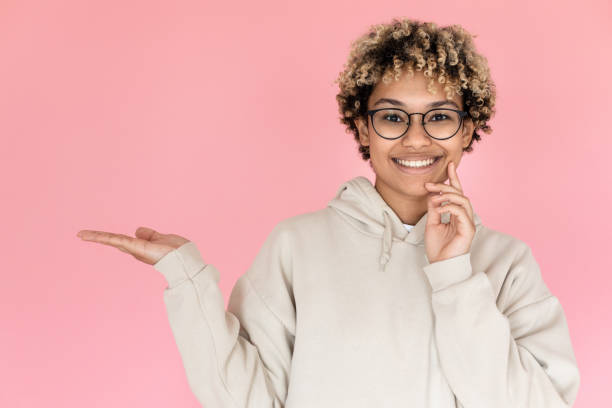 istock Smiling African American woman pointing copy space 1421223111