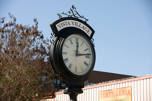 Vista, California, USA - February 13, 2022: Afternoon sunlight shines on a historic clock in the downtown district of Vista.