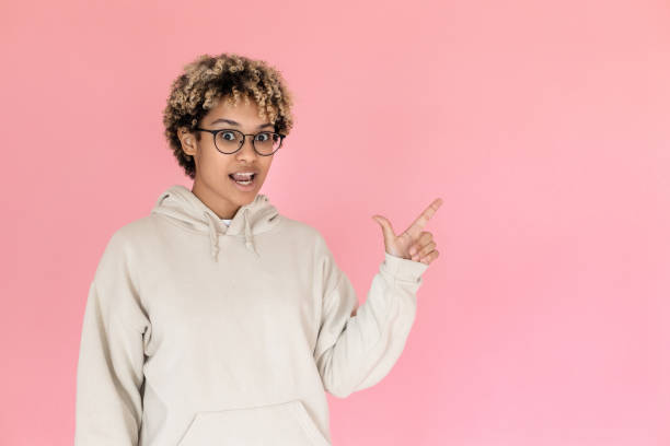 istock Funny African American woman pointing copy space 1421225135