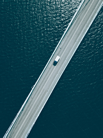 Aerial top view of bridge road with cars over blue lake in summer Finland