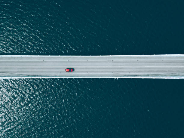 vista aerea dall'alto della strada del ponte con le auto sul lago blu - industry water sky architecture foto e immagini stock