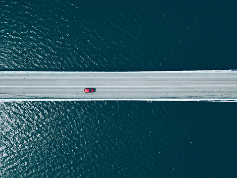 Aerial top view of bridge road with cars over blue lake in summer Finland