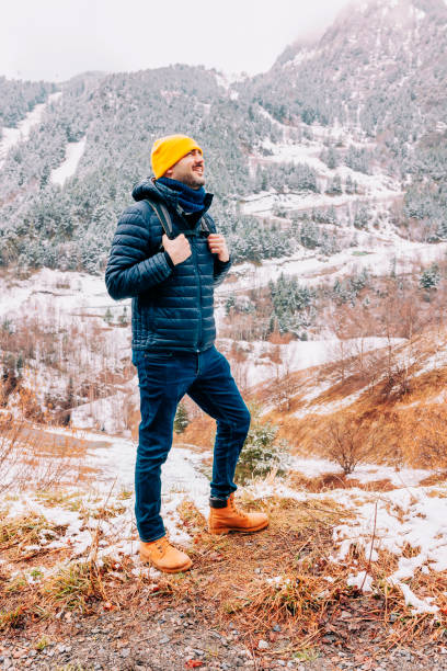 Young happy hiker man walking on snow at winter