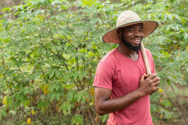 istock smiling african farmer carrying a hoe 1421229855