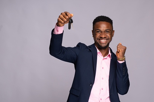 black man holding a car key jubilating