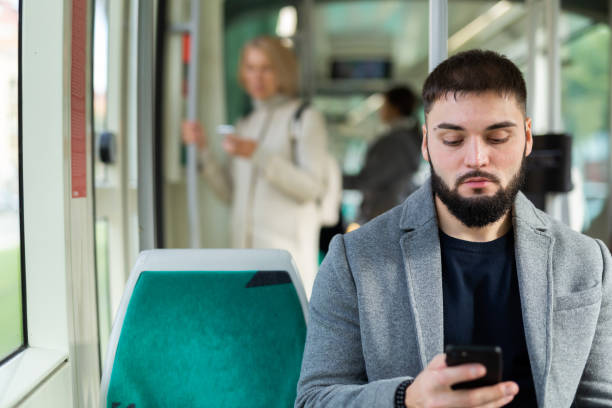 istock Young man with phone in city bus 1421233844