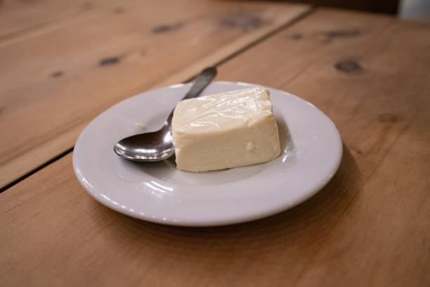 istock Closeup of the white cheese on a plate with a spoon. 1421234441