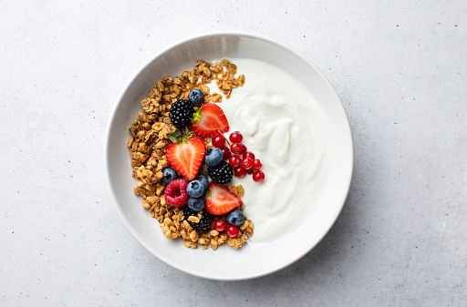 Granola with yogurt and fresh berries, top down view