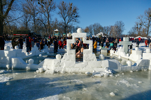 Ukraine, the city of Romny, January 19, 2022: the feast of the Baptism of the Lord. Orthodox rite of bathing in the ice hole. Epiphany. Many people come to swim in the winter river.