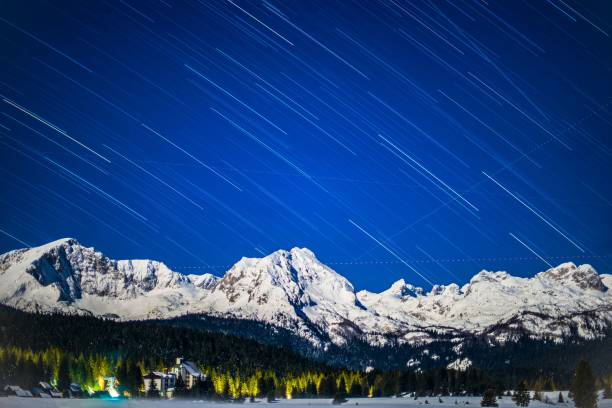 istock Star trail over snowy mountains 1421236700