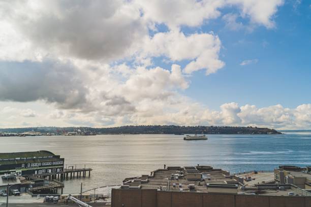 istock Washington Ferry sails on Elliot Bay with West Seattle and Cloud sky background 1421236933