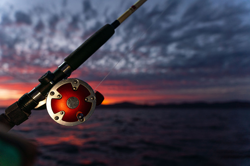 Deep Sea Fishing Reel on a boat during sunrise . High quality photo