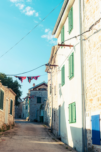 Old narrow street with stone buildings. Murter island, Croatia.