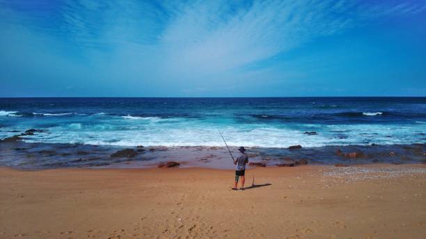 istock Alone fisherman on Beach 1421237128