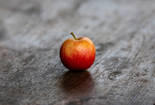 A closeup of a ripe apple on a wooden surface