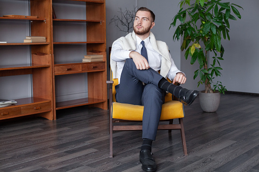 Young man relaxing and sitting on armchair