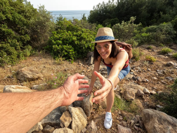 istock Boyfriend Helping Girlfriend Climb Up The Mountain 1421240221