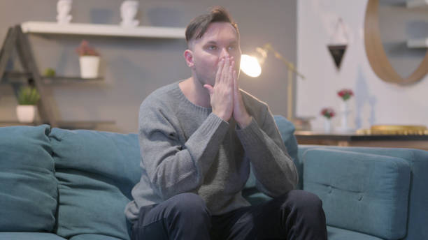 istock Upset Casual Man Feeling Worried While Sitting on Sofa 1421245279