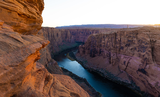 Aerial view at the Grand Canyon. The Colorado river is flowing at the bottom of the canyon while the sunset is taking place. Seen near the city of Page, Arizona, USA.