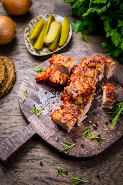 istock Roasted pork belly with crust and herbs on cutting board 1421247152