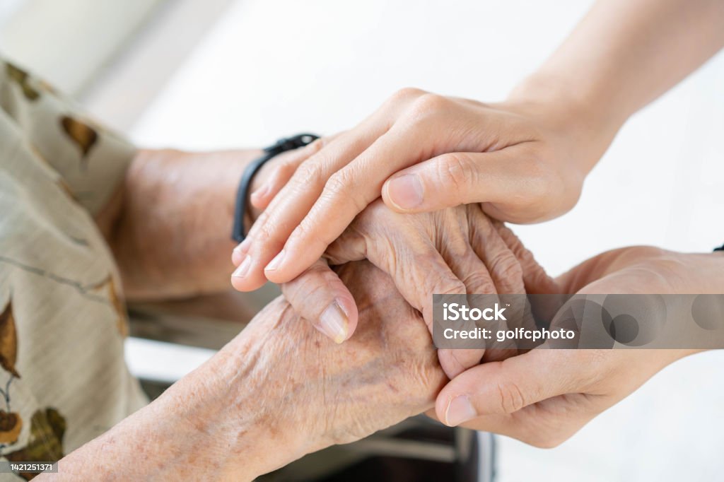 Woman taking care old woman. Young granddaughter taking care of grandmother with tender and care. Wrinkled hands of very old woman and young hands of teen woman close up, the change of family generation. Healthcare and wellness. Respect Stock Photo