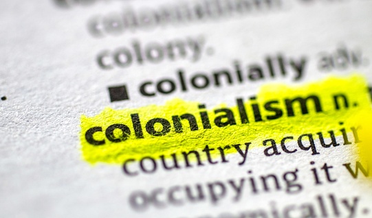 Close up photo of the word colonialism in a dictionary book