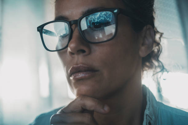 Technology concept people portrait with digital charts reflected on eyewear. One woman in business online modern activity looking a display with reflection on glasses. Concept of businesswoman alone stock photo