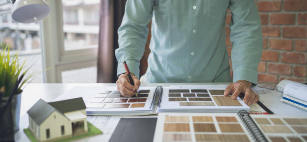 istock Architect Design Concept, Asian engineer work on Blueprint Construction drawing and house model On the desk in the office glass wall.Selective Focus at hand 1421255986